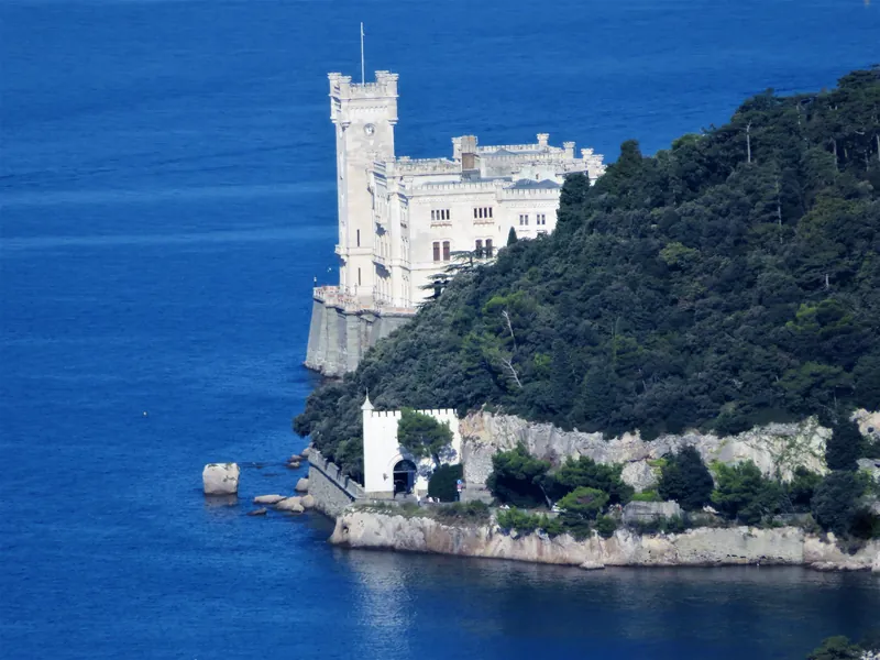 Il castello sulla punta del promontorio visto dall'alto, circondato dal mare blu