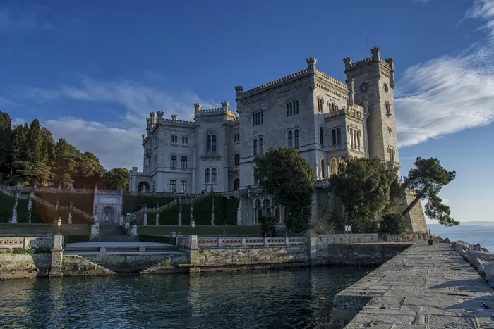 Il castello visto dal molo, con le scale che scendono al mare e le nuvole