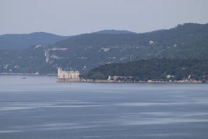 Il castello visto da lontano attraverso il golfo, con il Carso alle spalle