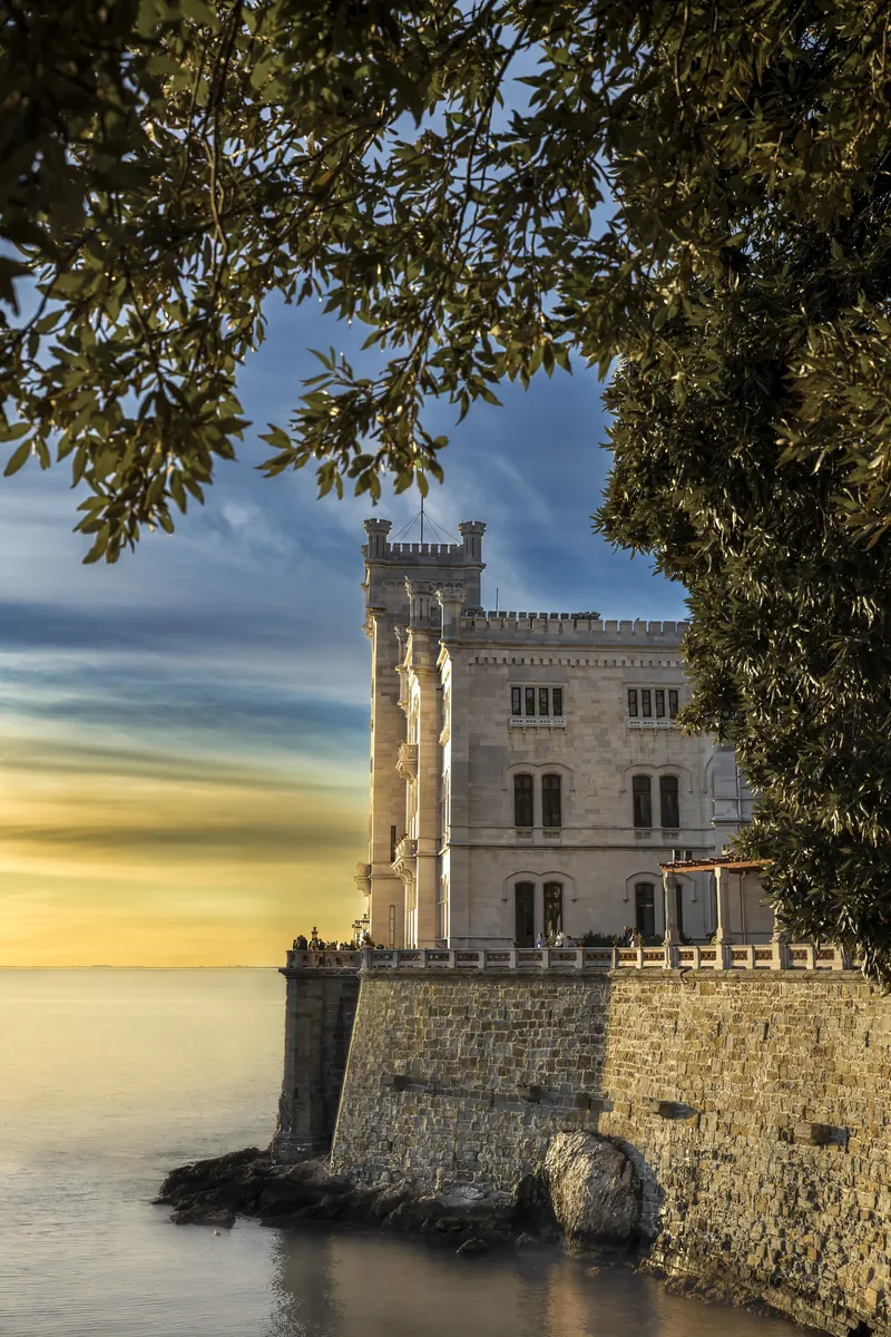 Il castello al tramonto, con la luce dorata che filtra tra gli alberi