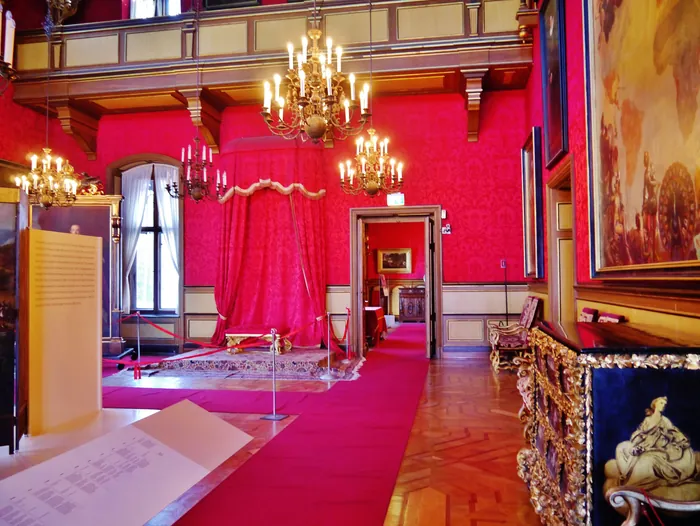 La Sala del trono con le pareti rosse, i lampadari di cristallo e il baldacchino